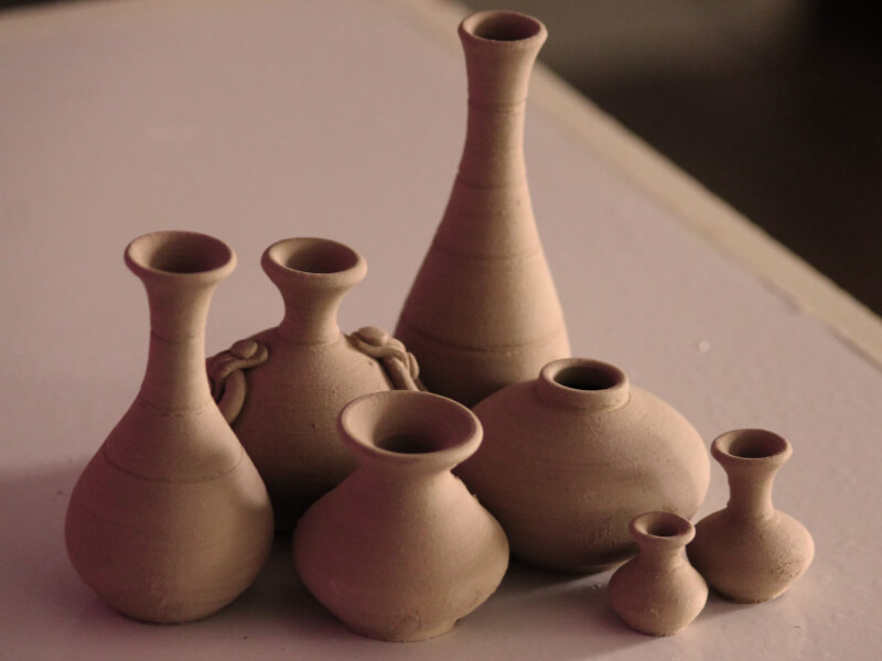 Several tan coloured clay pots of different shapes and sizes.